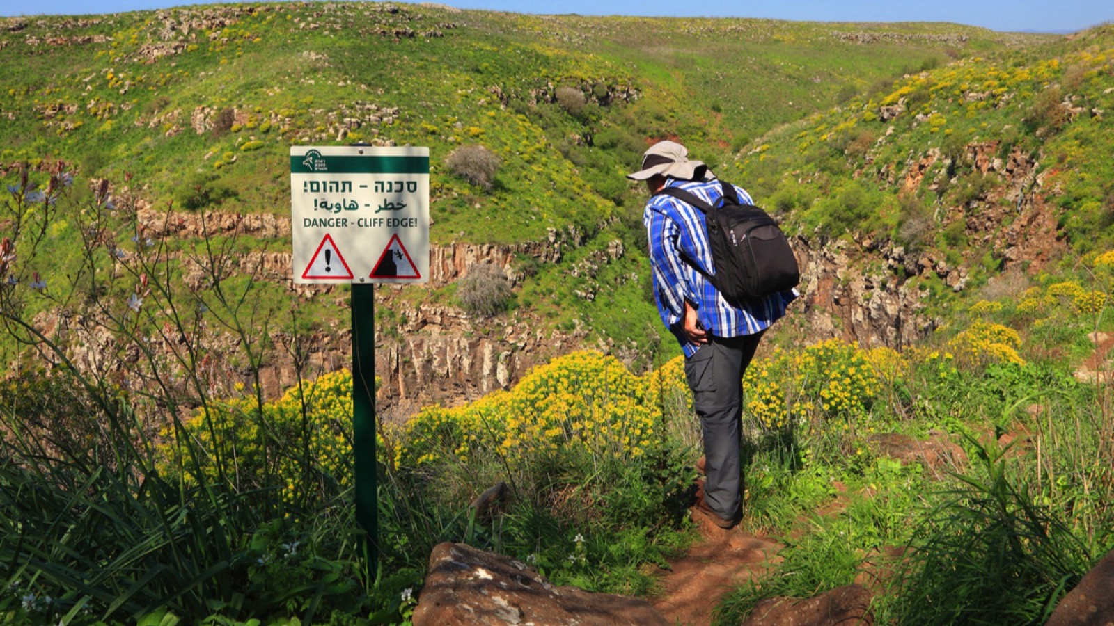 Traveler looking at hiking sign board